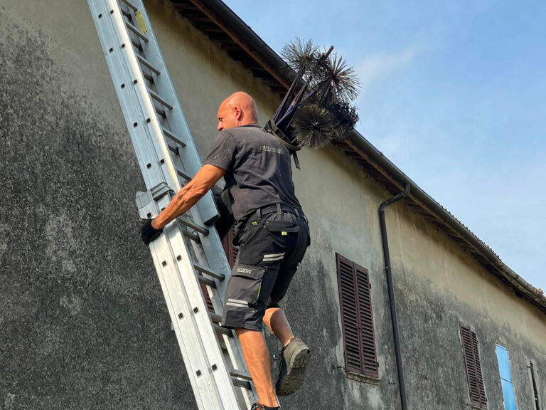 Spazzacamino mentre sale sul tetto per un intervento